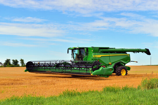 A new John Deere combine sits in a field of wheat in Illinois farm country. This modern piece of farming equipment, at the time the photograph was taken, cost between $740,000 and $780,000 new. 
