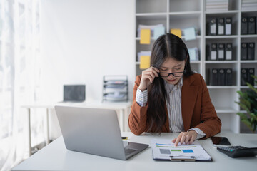 businesswoman plans a finance audit, reviewing documents while battling burnout syndrome.