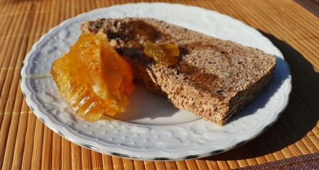 Wholegrain bread with fresh honeycomb on a white plate.