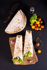 wrap sandwich with ham, lettuce, tomatoes and cheeses