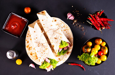 wrap sandwich with ham, lettuce, tomatoes and cheeses