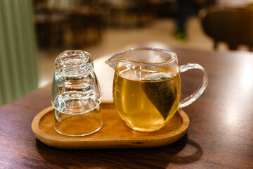 Brewed green tea in a bag. Jasmine tea in a glass jug on a tray