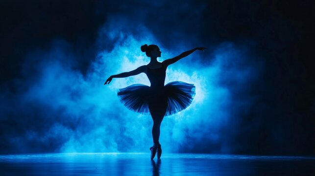 Ballerina in black tutu dress dancing on stage with magic blue light and smoke. Silhouette of young attractive dancer in ballet shoes pointe performing in dark. Copy space.