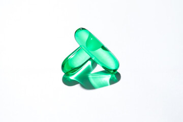Vitamin E softgel capsules, vitamin D3, fish oil, omega 3, Green oil pills on a white background