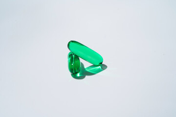 Vitamin E softgel capsules, vitamin D3, fish oil, omega 3, Green oil pills on a white background