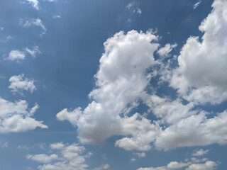 Obraz premium A vast expanse of sky, painted in the softest hues of blue, is adorned with fluffy white clouds. The gentle contrast between the deep blue and the bright white creates a serene and calming image.