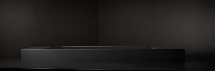 A sleek, modern black rectangular sink sits on a dark surface, its clean lines and minimalist design creating a striking contrast against the backdrop.