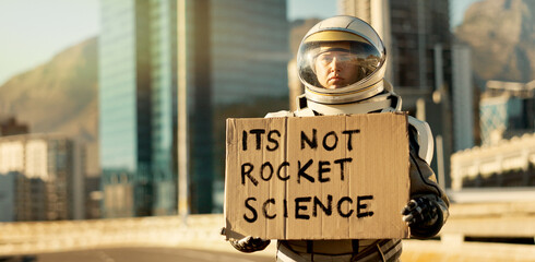 Woman, astronaut and helmet with cardboard in future for message alert, education poster and environment news. Person, spacesuit and travel banner of planet safety, mission emergency and journey sign © HockleyM3/peopleimages.com