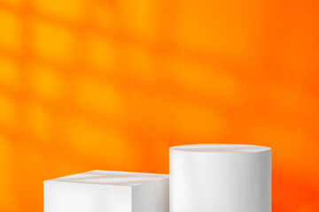 White geometric shapes on a vibrant orange background with soft shadows in a well-lit indoor setting