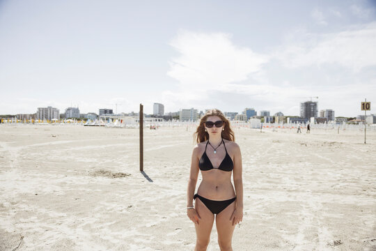 Girl standing on a beach wearing a bikini. Lido degli Esters