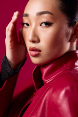 Fashion, asian, brunette woman in red leather jacket posing with hand on head and red lipstick