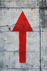A bold red arrow on a grey concrete wall