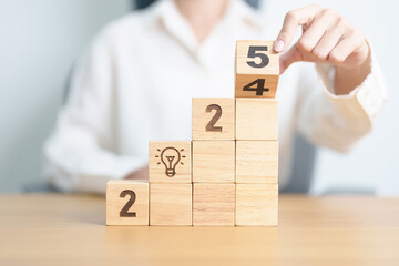 2024 year change to 2025 year block with lightbulb. Business Idea, Creative, Thinking, brainstorm,...