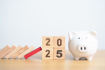 wood block falling to 2025 year with money piggy. risk management, financial, deflation and Inflation, Insurance and economic recession