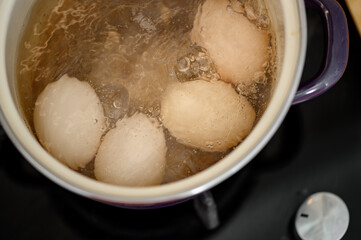 Chicken eggs cooked in their shells in an enameled pot