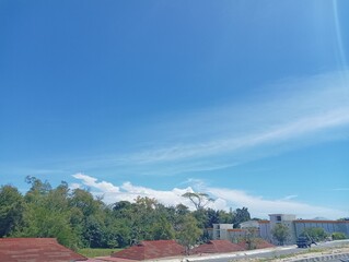 Obraz premium Blue Sky with White Clouds and Buildings with Red Roofs