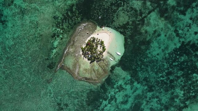 Aerial drone shot of Guyam Island in Siargao, Philippines, showcasing a pristine white sand beach, clear turquoise waters, and lush tropical scenery, Perfect for nature or travel themed projects.