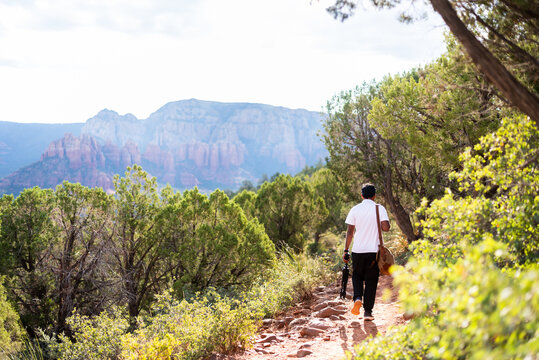 Man hiking on a Sedona trail with a view of red rock formations