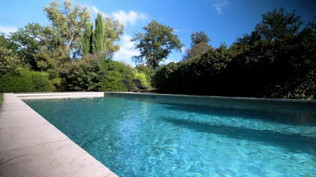 Low dolly shot along the stone slabs beside a private pool in France