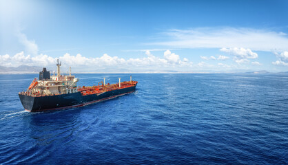 Aerial view of a crude oil or chemical goods tanker ship traveling over the ocean with copy space