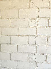 Fototapeta premium White painted bricks form a textured wall with signs of weathering and age. Old brick pattern wall texture on white