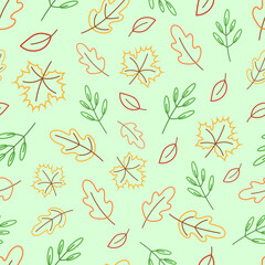 Seamless vector pattern with autumn colored leaves on a green background
