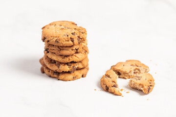 stacked chocolate chip cookies on white background