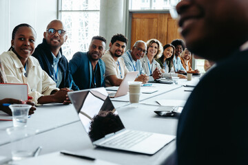 Diverse group of colleagues in a business meeting at the office, seated around a large conference table