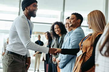 Creative business people greeting each other in modern conference setting