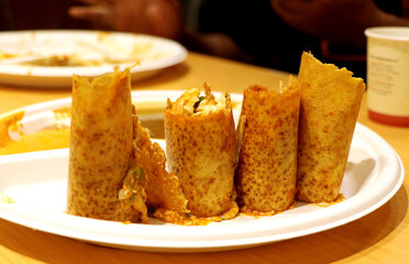 Plate full of delicious Indian pizza Dosa wraps with sambhar and chutney sauces at vrindavan