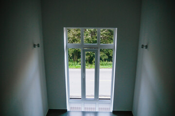 Bright entrance with glass doors leading to a serene outdoor view in a modern building during...