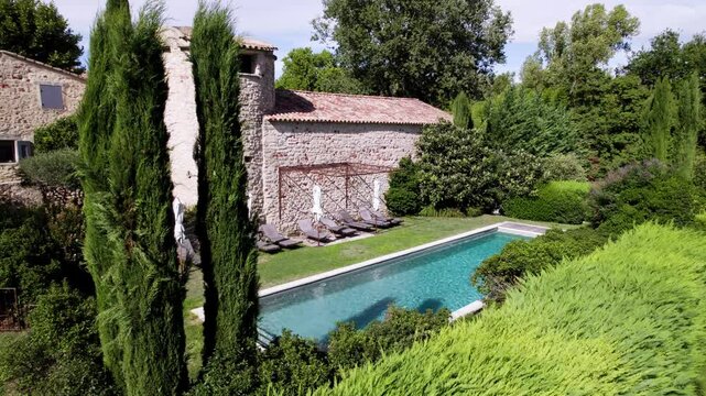 Aerial orbiting shot of a stone villa in France with a private pool
