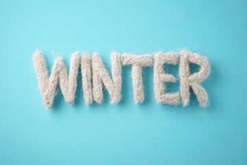 Word "WINTER" made of cozy soft alpaca wool, light blue empty minimalistic background, concept of winter season, cold, hobbies and knitting, banner with space for text