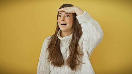 Young hispanic woman with long hair wearing a white sweater over a yellow background, looking away with a hand over her eyes