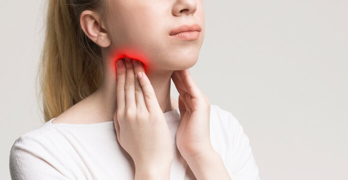 Woman with thyroid gland problem, touching her neck, closeup, panorama