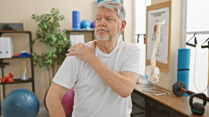 Obraz premium Mature man with shoulder pain at a physiotherapy clinic indoor.