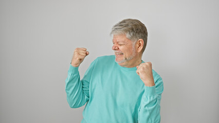 A joyful senior man with grey hair celebrates against a white isolated background, embodying energy...