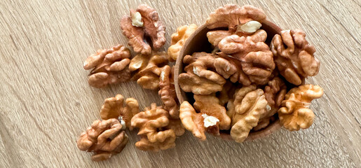 Walnuts kernels on dark desk with color background, Whole walnut in wood vintage bowl.