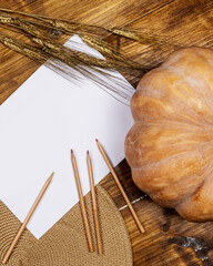 white sheet with crayons pumpkin ears of wheat and wooden background