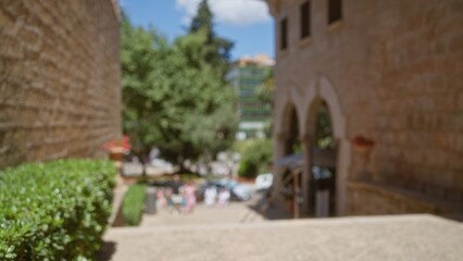 Blurred outdoor scene in mallorca, spain, featuring defocused people, trees, and historic buildings in the background