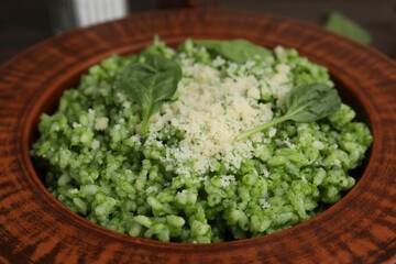 Delicious spinach risotto with parmesan cheese on table, closeup