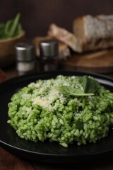 Delicious spinach risotto with parmesan cheese served on table, closeup
