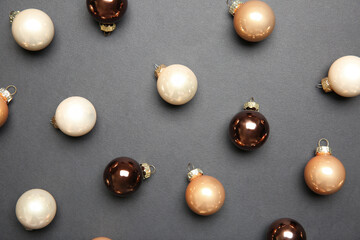 Many shiny Christmas baubles on grey background, flat lay