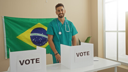 A handsome young hispanic man in medical scrubs stands at a voting station in an indoor electoral...