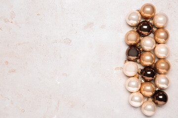 Shiny Christmas tree baubles on light textured table, flat lay. Space for text