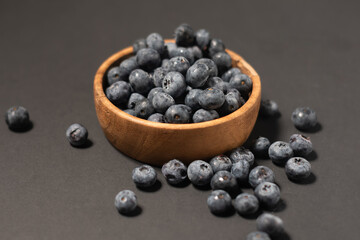 Delicious fresh sweet blueberries on a dark background, a bowl of blueberries in dark background, Blueberries in a wooden bowl on a black, healthy food