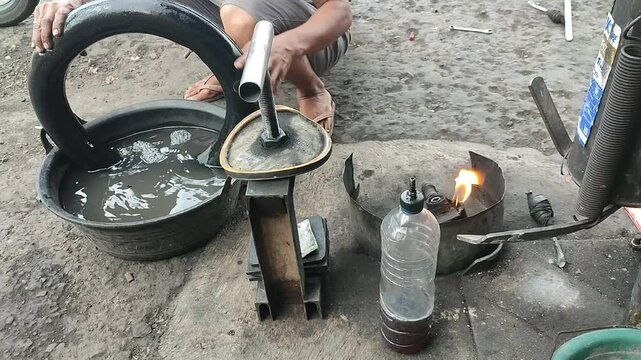 Traditional street mechanic checking a flat motorcycle tire