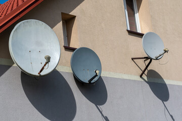 satellite dish on roof,three satellite dishes on the front of the house on the background wall,...