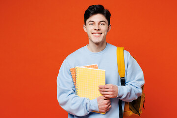 Young smiling happy smart fun cool man student he wearing blue casual clothes backpack bag holding...