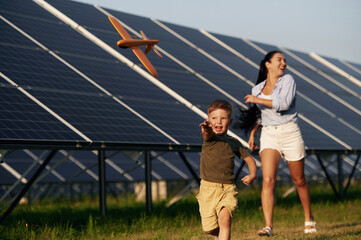 Mother with her little son are near the solar panels